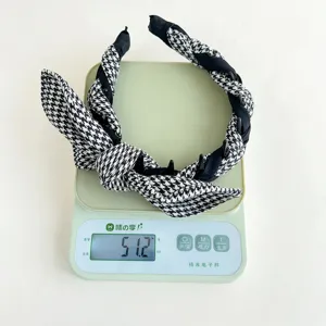 Detailed view showing the weight of the houndstooth rabbit ear knotted headband