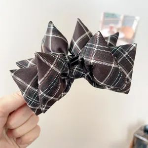 Close-up detail of a vintage brown plaid bow hair clip for elegant autumn hairstyles
