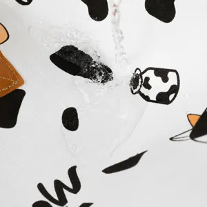 Waterproof quilt storage bag fabric close-up with cute cow print pattern design.