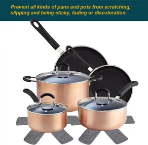 Primer plano de protectores de fieltro gris para sartenes y ollas de color cobre metálico