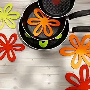 Detailed view of flower-shaped felt pan protectors used between stacked frying pans