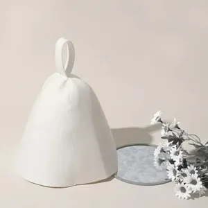 Close-up view of a minimalist white wool felt sauna hat featuring a practical top hanging loop