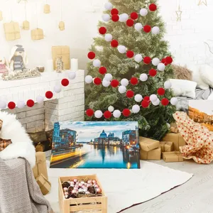 Festive red and white wool felt ball garland hung on a Christmas tree in a cozy room