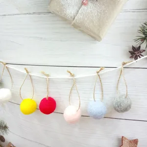 Close-up of colorful handmade wool felt ball garland for Christmas holiday home decor
