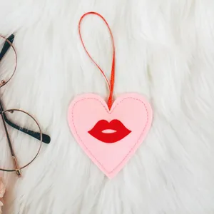 Detalle de adorno de fieltro rosa en forma de corazón con labios rojos para San Valentín