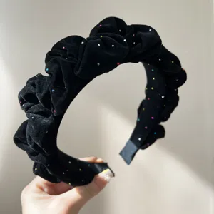 Macro detail of a black velvet ruched headband with colorful star-like rhinestones