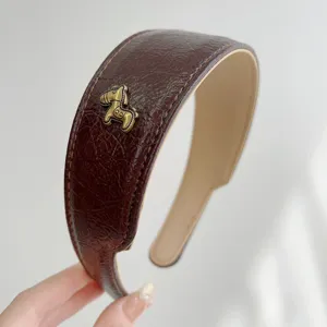 Nahaufnahme von Vintage braunem Leder Stirnband mit antikem Gold Pferd Anhänger.