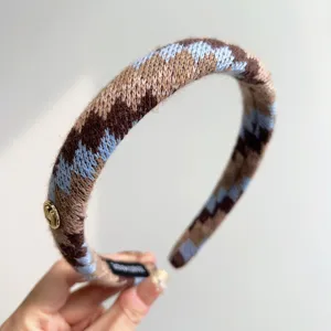 Close-up van een gebreide hoofdband in Fair Isle-stijl met blauwe en bruine patronen
