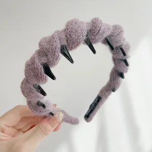 Detailopname van mauve wollen hoofdband met antislip tanden voor hoog hoofdeffect