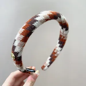 Gedetailleerd overzicht van een retro gebreide hoofdband met geometrische patronen.