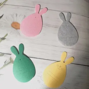 Detailed view of colorful rabbit-shaped felt cutlery holders for Easter table decoration