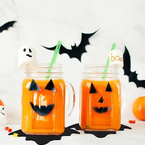 Close-up of black felt bat placemats under jars for Halloween party table decoration