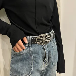 Retro punk style leather belt with metal floral buckle and rivet decorations for jeans.