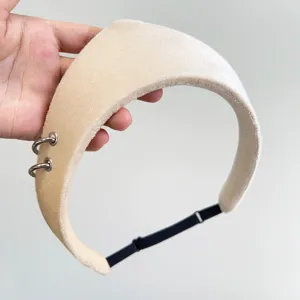 Macro detail of a cream velvet padded headband featuring decorative silver metal rings