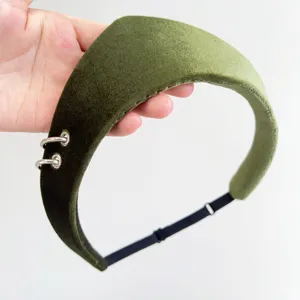 Close-up of olive green velvet headband with silver metal rings and adjustable strap
