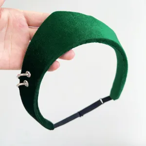 Close-up of a green velvet headband with silver ring accents and adjustable strap.