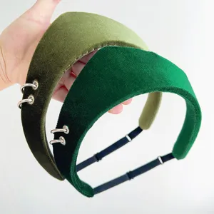 Close-up of green velvet headbands with silver rings and elastic adjustable straps.