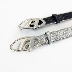 Close-up detail of trendy black and silver sequin rhinestone belts with oval letter A buckles.