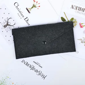 Detailed view of a charcoal gray felt envelope pouch with a sleek black button closure