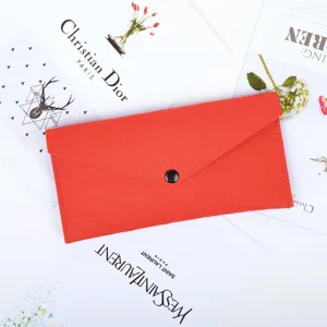 Premium red felt envelope pouch with a minimalist black button closure on a floral flat lay