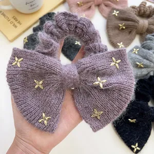 Detail van paarse nertswollen strik scrunchie met gouden ster strass versieringen