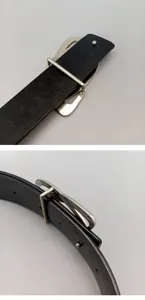 Detail of women's black leather belt featuring a unique minimalist silver metal buckle.