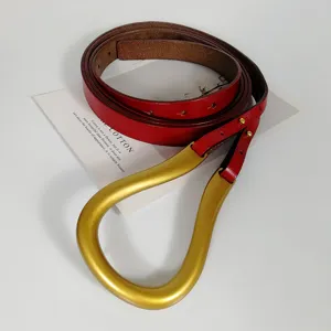 Stylish red leather belt with large gold horseshoe buckle for women dresses coats waist accessory.
