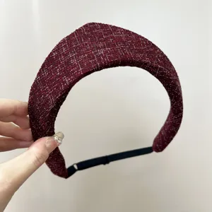Vue détaillée d'un serre-tête en tweed bordeaux à pointe avec des fils métalliques argentés.