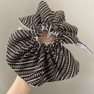 Detailed view of oversized brown scrunchie with leaf embroidery and gold sequins