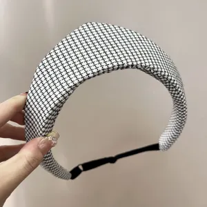 Gros plan d'un bandeau en tweed noir et blanc avec sangle réglable et style rétro