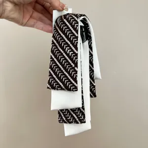 Close-up of black and white sequin ribbon hair tie with elegant embroidery details