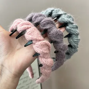 Detailweergave van drie gebreide antislip haarbanden met tanden in diverse kleuren