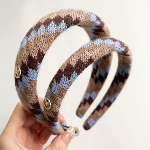 Detailopname van retro Fair Isle gebreide hoofdband met blauwe en bruine zigzagpatronen