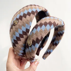 Detailopname van een vintage Fair Isle gebreide hoofdband met gouden metaal M-logo