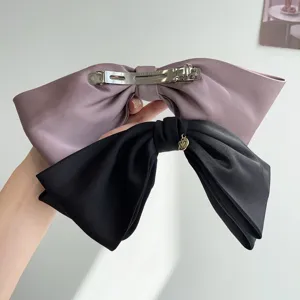 Close-up of elegant satin bow hair clips showing back spring clip and fabric texture
