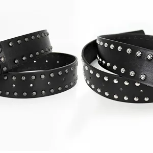 Black leather studded belt with double rows of metal studs, punk rock style fashion accessory.