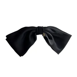 Elegant black fabric bow hair clip with golden heart charm on white background