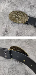 Nahaufnahme der dekorativen Vintage Blumen Metall Schnalle schwarzer PU Ledergürtel.
