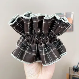 Detailed close-up of a vintage brown plaid ruffled hair scrunchie with fine stitching