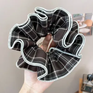 Macro view of vintage brown checkered pleated scrunchie with a delicate white trim