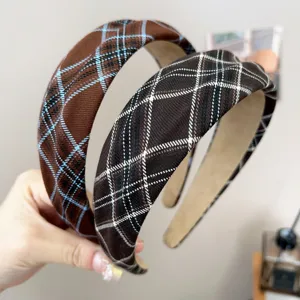 Close-up of retro brown and black plaid wide headbands featuring textured fabric.