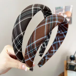 Macro shot showing details of retro plaid fabric headbands in brown and blue patterns.