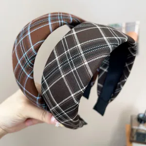 Close-up detail showing the texture of retro plaid wide headbands in brown and dark brown