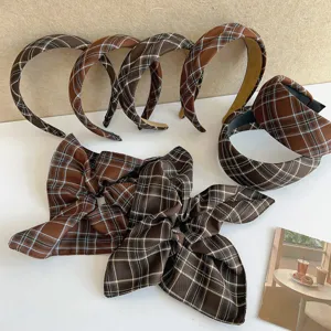 Collection of vintage brown plaid headbands and large pleated scrunchies displayed on white surface.