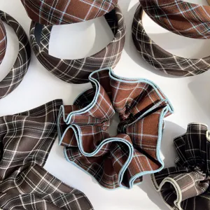 Close-up detail showing the vintage brown plaid fabric texture on scrunchie and headbands