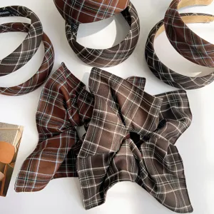 Detailed macro view of vintage brown plaid fabric scrunchies and padded headband set.