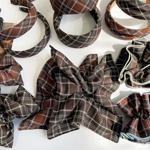 Macro detailed view of vintage brown plaid scrunchies and wide padded headbands set