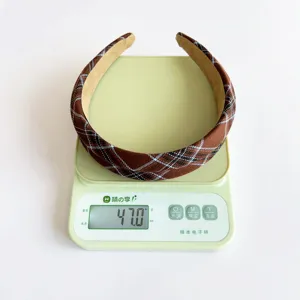 Weight measurement of this brown vintage plaid headband showing 47.0g on a digital scale