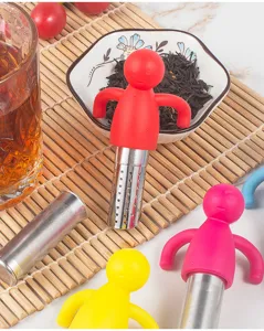 Detail shot of colorful silicone and stainless steel human shaped tea infusers on bamboo mat.