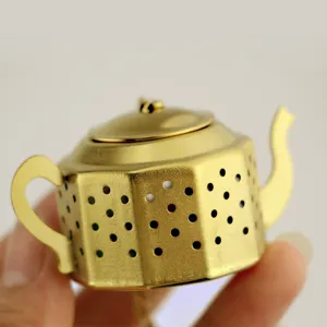 Vue détaillée de l'infuseur à thé théière polygonal doré avec trous fins et chaîne.